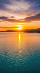 Obraz premium Majestic sunset over calm ocean and distant mountains