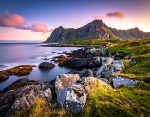 Coastal landscape features mountains, rocks, ocean, sky, and soft light