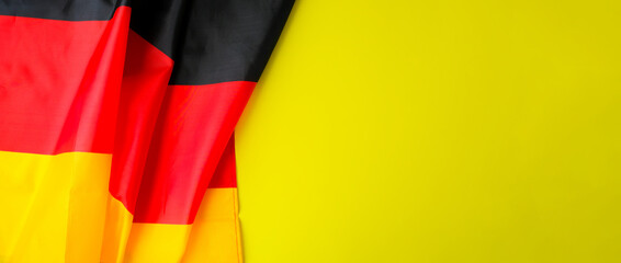 National symbol of Germany patriotic symbol on yellow background with place for text. German full framed wave Germany fabric flag. Copy space for your text. Concept of Independence