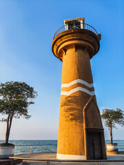 The tower sits on beautiful blue seaside in Bali Hai Cape, Pattaya, Thailand. Beautiful view of public lighthouse on bright sunny day on blue sky background. Bali hai Lighthouse landmark of Pattaya.