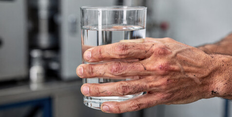 Male worker hand with satisfaction holds glass of clear, pure water in lab. Modern purification technologies ensure high quality drinking water from treatment process