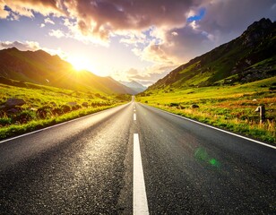 Asphalt road leading to mountains under a sunset