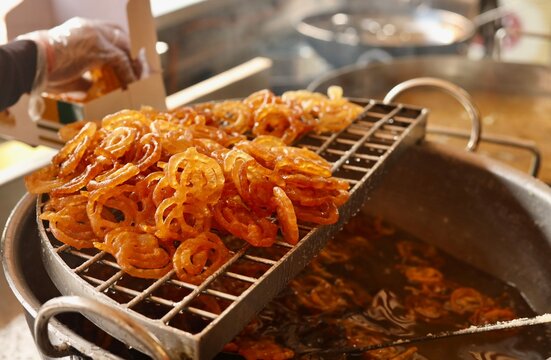 Jalebi being deep fried at a sweet shop in morning