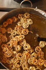 Jalebi being deep fried at a sweet shop in morning