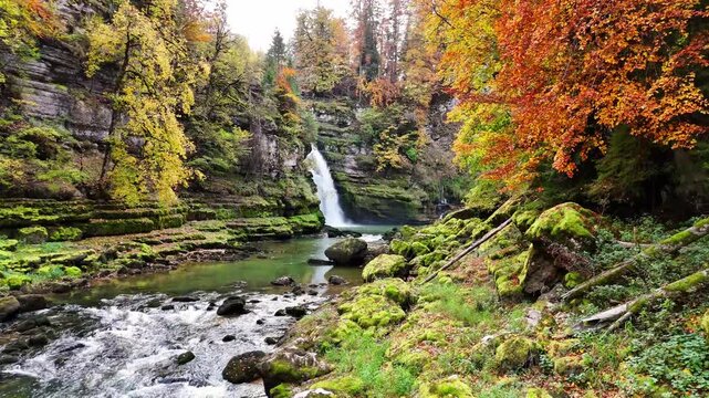 Drone push‑in along the river towards the Saut du Doubs waterfall on the Doubs River between Villers‑le‑Lac in Doubs, Bourgogne‑Franche‑Comt&eacute;, France and Les Brenets in Switzerland