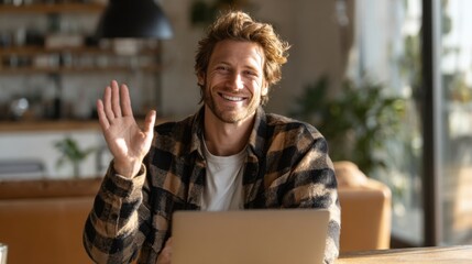 Friendly Male Smiling and Waving While Sitting at a Desk