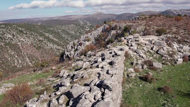 Aerial view of the ancient Daorson Illyrian city ruins near Stolac, Bosnia and Herzegovina, showing stone walls, rocky terrain and panoramic mountain landscape under clear autumn light.