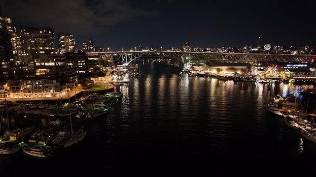 Gimbal wide tilting-up shot of False Creek from Burrard Bridge at night in Vancouver, British Columbia, Canada. 4K