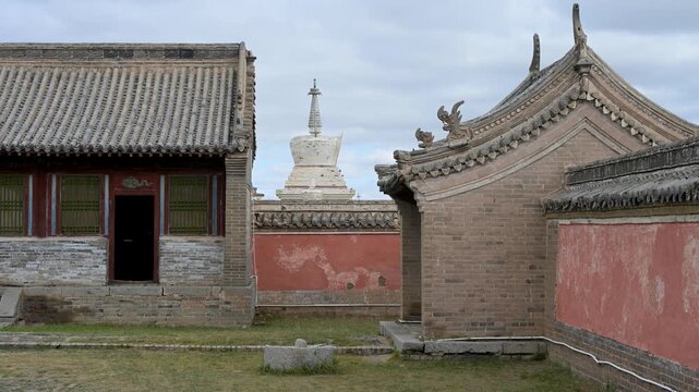 Historic roof detail at Erdene Zuu, Mongolia's oldest monastery. The green tiled pavilion features a golden Dharma Wheel flanked by deer, a traditional symbol of Buddhist teaching and ancient heritage