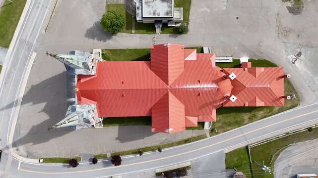Aerial view of St Ann Catholic Church near Sainte Anne des Monts in Quebec town with houses and mountains. g.