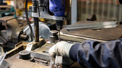 Drilling an aluminum frame with a drill press in a metalworking factory