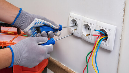 electrician fixing electrical outlet