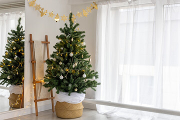 Christmas tree with gifts garlands in the white cloud dancer interior with large window and mirror for new year, copy space
