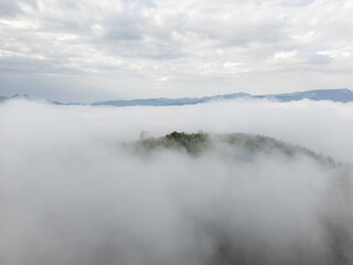 Fog drifting over forested hills creating mysterious mood