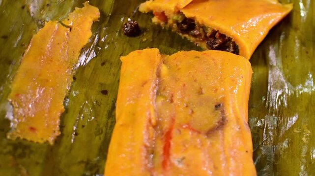 Delicious and freshly cooked Venezuelan hallaca, a festive corn dough meal with stew, slowly turning for a detailed view.