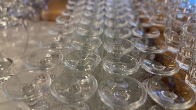 Rows of inverted crystal wine glasses create an elegant abstract glassware background