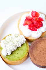 Various kinds of mini cheese tarts on a white plate