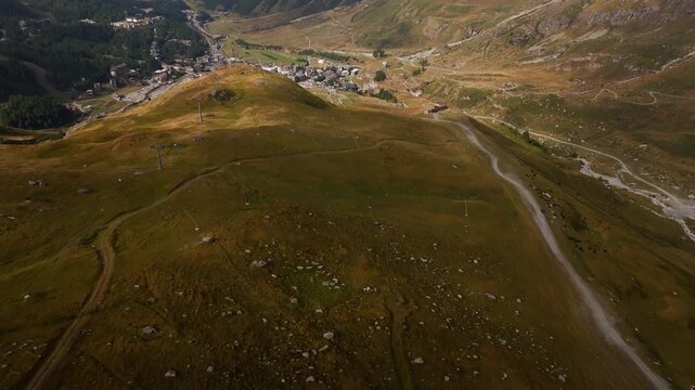 Rising aerial shot of a scenic landscape revealing a small town in Cervinia, Italy, Aosta Valley, Valle d&rsquo;Aosta, showcasing alpine scenery