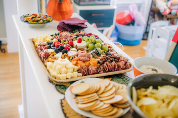 Charcuterie board filled with cheese, fruits, and meat