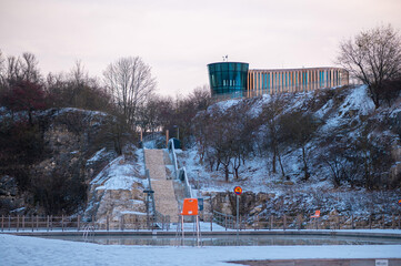 Snowy Outdoor Pool with Modern Hilltop Building
