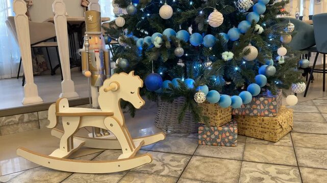 Christmas scene with decorated tree, gifts, nutcracker, and wooden rocking horse indoors