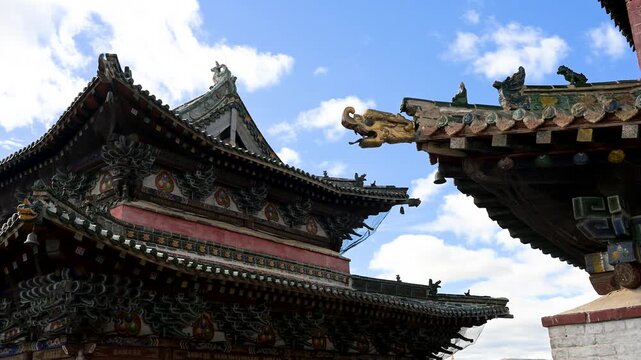 Traditional Buddhist-style roof architecture at Erdene Zuu, Mongolia. Close-up of ornate green tiles and golden mythical beasts on a historic Buddhist temple.