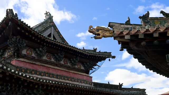 Weathered roof details of Mongolia's oldest monastery, Erdene Zuu. Features intricate clay figurines and dragon ornaments on the eaves of a sacred pavilion.