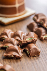 Chocolate bar with pistachios cream on wooden table.