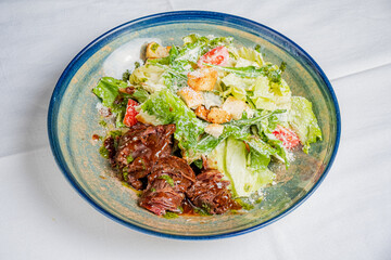 Fresh caesar salad with crispy greens and savory beef, offering a delightful taste experience