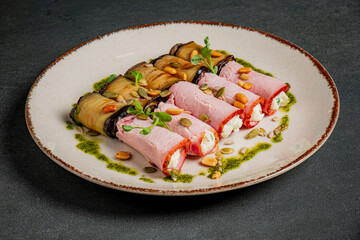 Colorful rolls of eggplant and creamy filling create a delightful dish, beautifully garnished