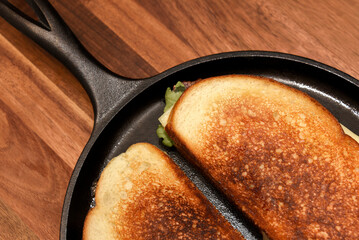 Turkey panini in a cast iron skillet with bacon, arugula and Swiss cheese