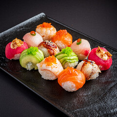 Savor the vibrant colors and textures of finely crafted sushi, displayed on a sleek black plate