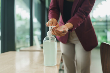 Woman applying hand sanitizer for office hygiene protection