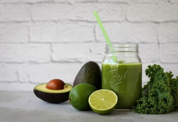 Fresh green smoothie with avocado lime and kale ingredients