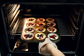 Baking berry muffins in hot oven for dessert
