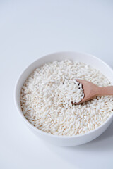 A bowl of white sticky rice grains isolated on white background