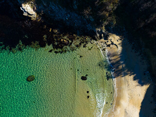 Scenic view of a tranquil beach at sunrise, capturing the crystal-clear waters and gentle waves whispering against the shore