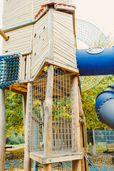 Colorful playground structure invites adventure and joy for children in a sunny park setting surrounded by vibrant autumn leaves