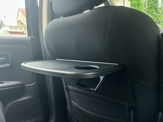 Innovative car seat design offering convenience during road trips with built-in tray and cup holder for snacks and drinks