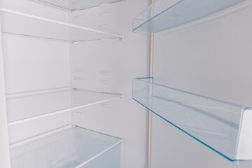 An Inside Look at an Empty Refrigerator Showcasing Its Spacious Shelves and Clear Glass Racks Perfect for Organizing Food and Beverages