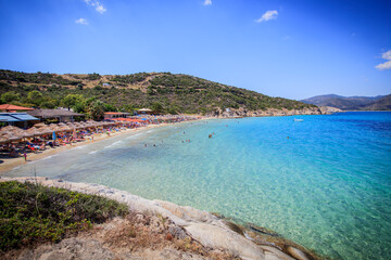 Idyllic turquoise bay with thatched umbrellas and sunbeds
