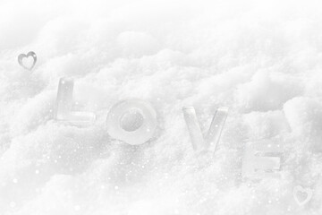 Soft silver background of snow and the word love. Ice letters. Heart. Valentine's Day. February 14.