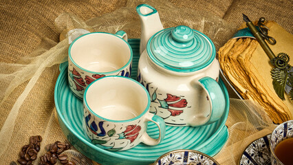 Handcrafted ceramic tea set with teapot and cups arranged in a warm rustic lifestyle still life.