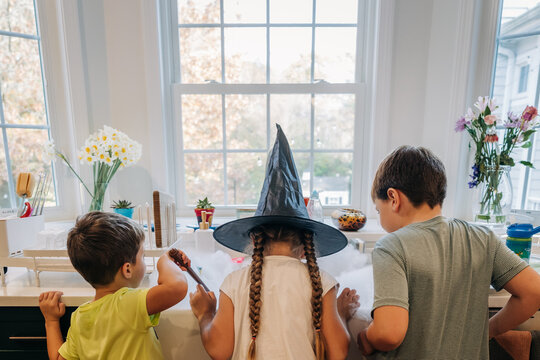 Children playing witch magic experiment in kitchen sink smoke