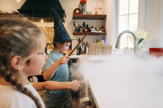 Kids playing magic game with dry ice smoke