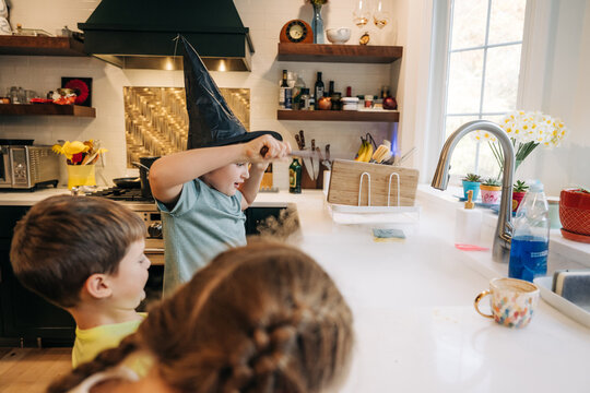 Children playing wizard in kitchen creating magic smoke