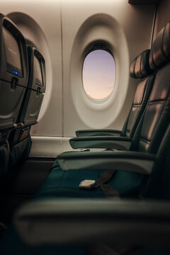 Soft light falls across empty airplane seats at the window.