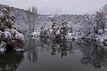 Soldier Lake after the first snow. A lake in a mountainous area with a variety of vegetation. November.