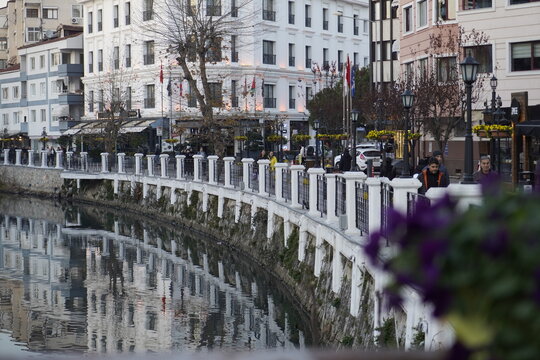 Footage of a scenic waterway canal in Eskişehir, Turkey, featuring calm flowing water and an urban riverside atmosphere. A popular city landmark known for its European-style canals and gondola rides. 