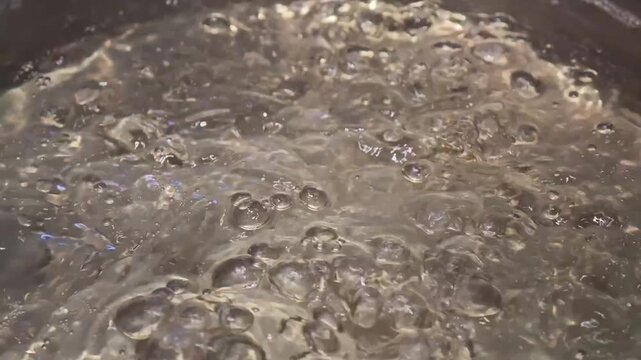 Close-Up of Bubbles Forming in Boiling Water in a Pan